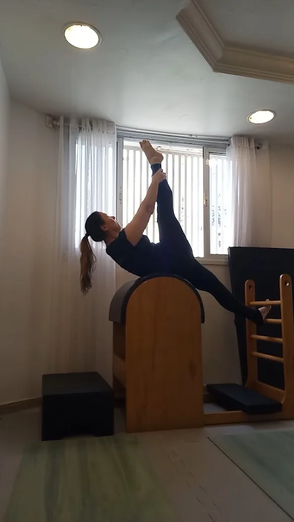 Flávia Sayuri fazendo um exercício no ladder barrel do estúdio